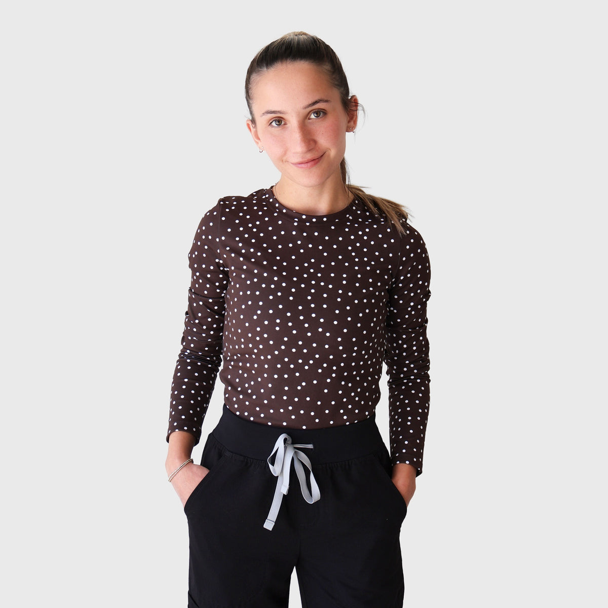 Chocolate PolkaDot CoreFit Underscrub, worn with black scrub pants