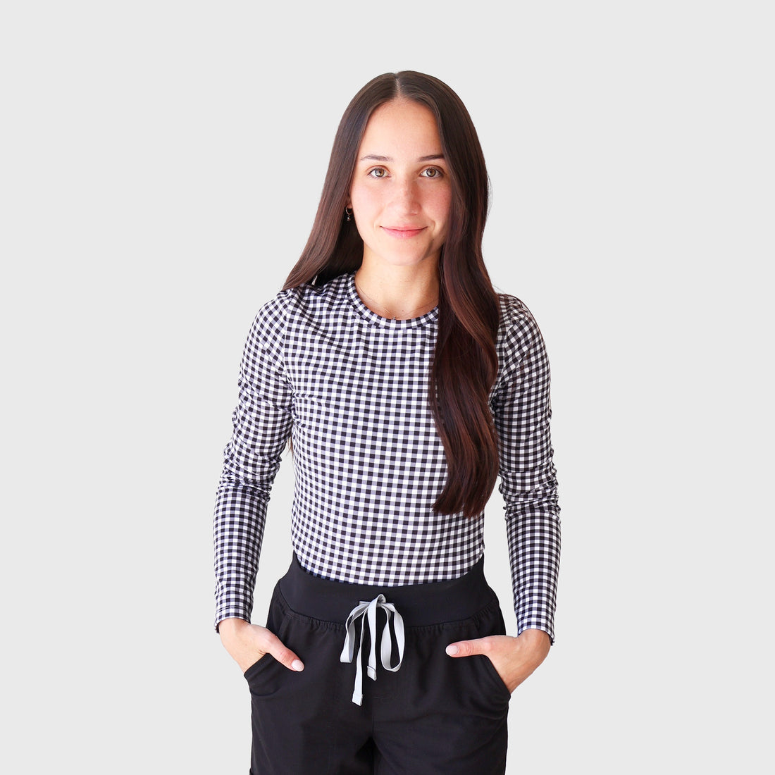 Black Gingham CoreFit Underscrub, front view: long-sleeve crew-neck top in black and white gingham, worn with black scrub pants
