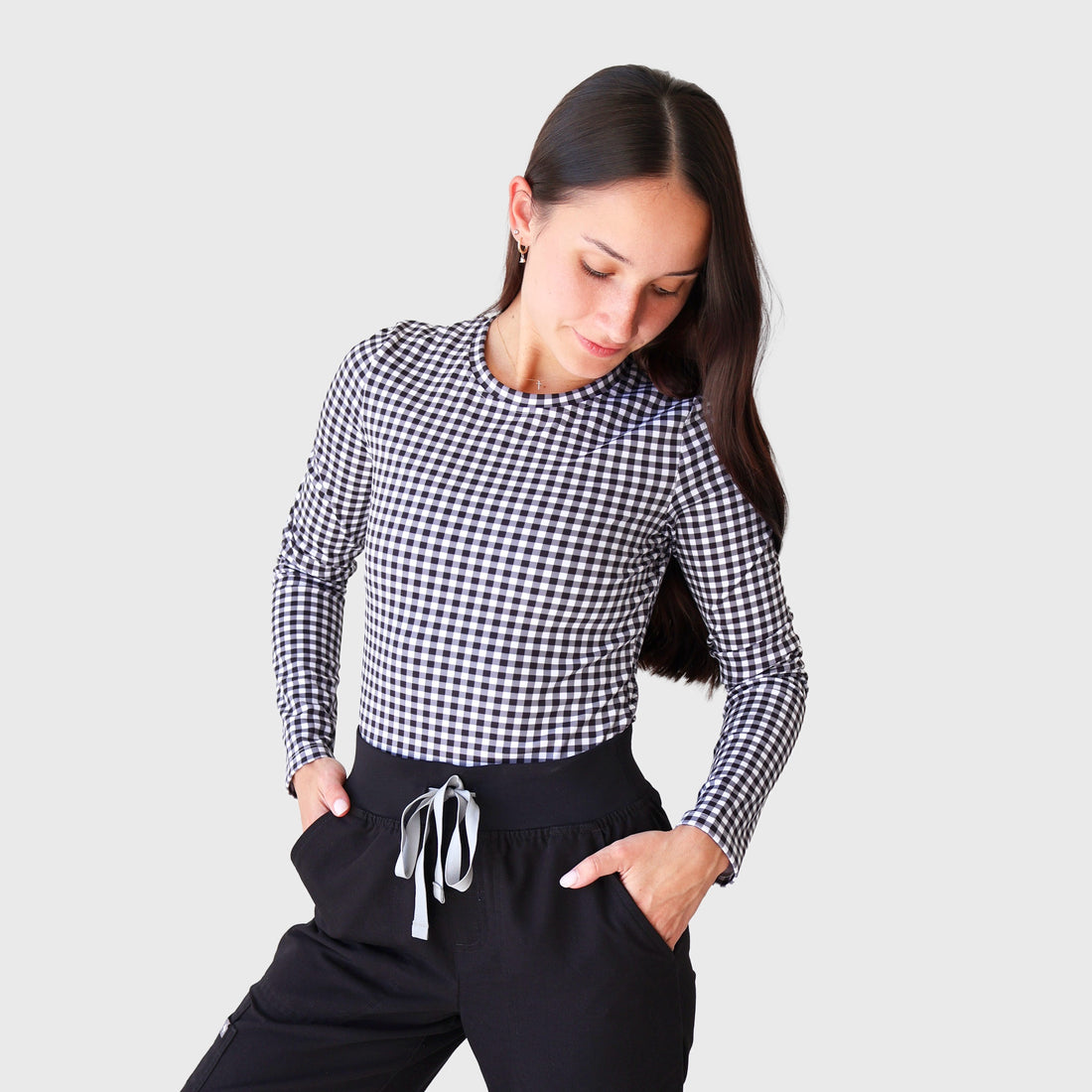 Black Gingham CoreFit Underscrub, front view: long-sleeve crew-neck top in black and white gingham, worn with black scrub pants