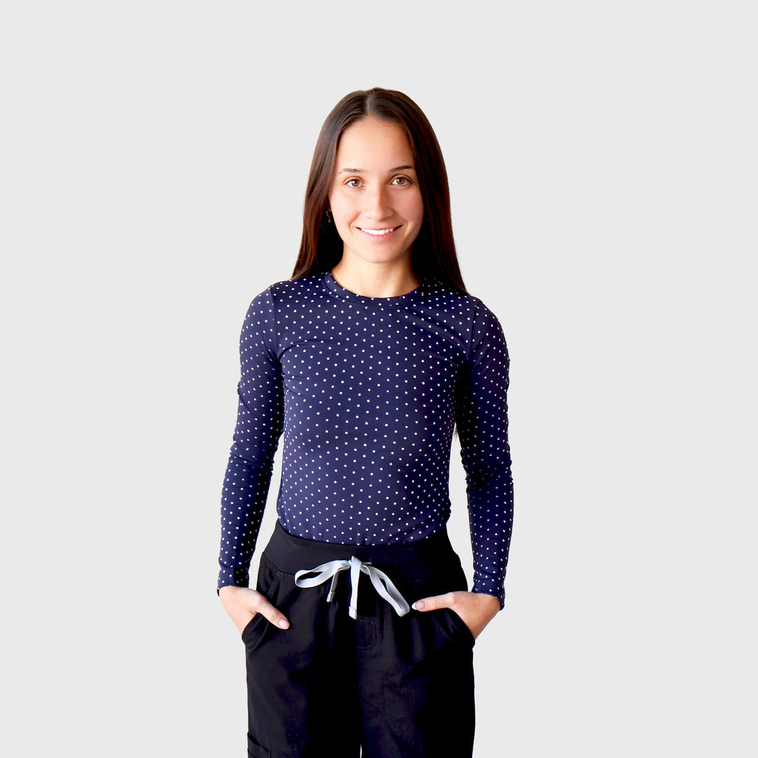 Navy & White PolkaDot CoreSupport Underscrub, front view: long-sleeve crew-neck top in navy with small white polka dots, worn under black scrub pants